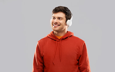 Image showing happy young man in headphones and red hoodie