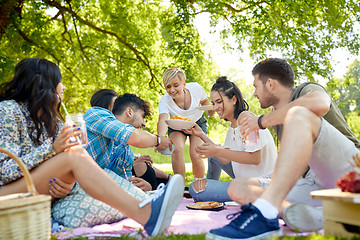 Image showing friends with drinks and food at picnic in park