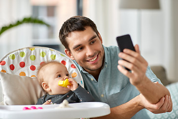 Image showing father with baby daughter taking selfie at home