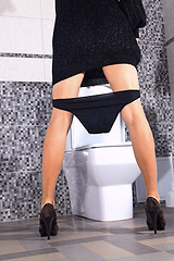 Image showing back of woman that stays near toilet bowl