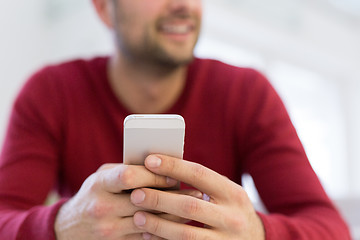 Image showing young man using a mobile phone  at home