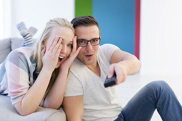 Image showing Young couple on the sofa watching television