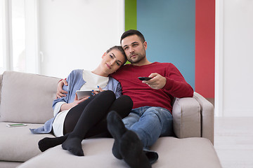 Image showing Young couple on the sofa watching television