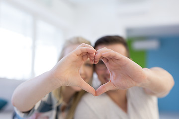 Image showing couple making heart with hands