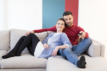 Image showing Young couple on the sofa watching television