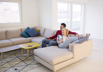 Image showing Young couple on the sofa watching television