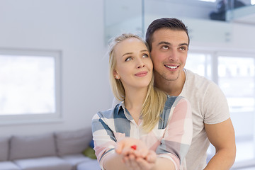 Image showing couple showing small red house in hands