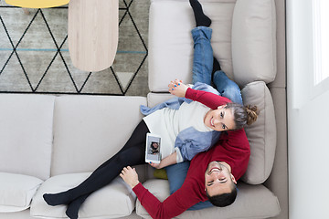 Image showing couple relaxing at  home with tablet computers