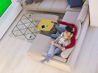 Image showing Young couple on the sofa watching television