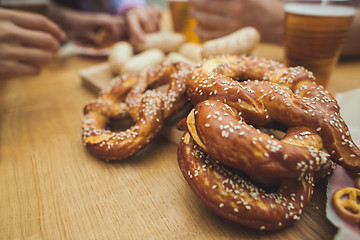 Image showing Boiled white sausages, served with beer and pretzels. Perfect for Octoberfest. Natural wooden background.