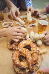 Image showing Boiled white sausages, served with beer and pretzels. Perfect for Octoberfest. Natural wooden background.