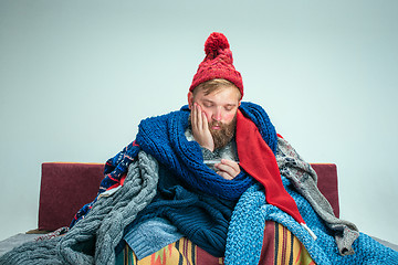 Image showing Bearded Man with Flue Sitting on Sofa at Home. Healthcare Concepts.