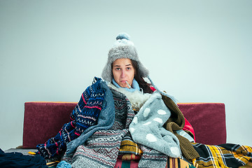 Image showing The young woman with Flue Sitting on Sofa at Home. Healthcare Concepts.