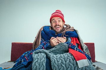 Image showing Bearded Man with Flue Sitting on Sofa at Home. Healthcare Concepts.