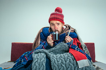 Image showing Bearded Man with Flue Sitting on Sofa at Home. Healthcare Concepts.