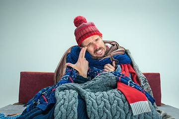 Image showing Bearded Man with Flue Sitting on Sofa at Home. Healthcare Concepts.