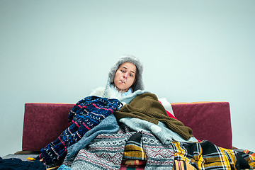 Image showing The young woman with Flue Sitting on Sofa at Home. Healthcare Concepts.