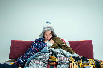 Image showing The young woman with Flue Sitting on Sofa at Home. Healthcare Concepts.