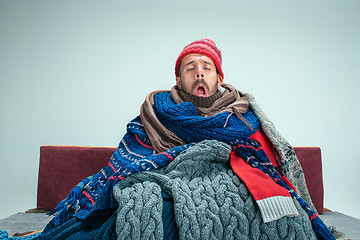 Image showing Bearded Man with Flue Sitting on Sofa at Home. Healthcare Concepts.