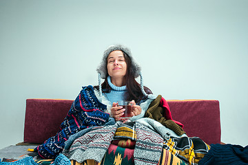 Image showing The young woman with Flue Sitting on Sofa at Home. Healthcare Concepts.