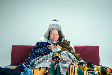 Image showing The young woman with Flue Sitting on Sofa at Home. Healthcare Concepts.