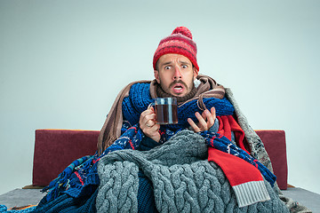 Image showing Bearded Man with Flue Sitting on Sofa at Home. Healthcare Concepts.