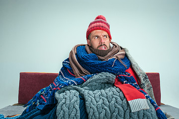 Image showing Bearded Man with Flue Sitting on Sofa at Home. Healthcare Concepts.