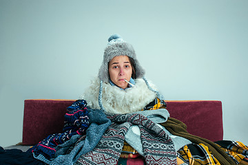 Image showing The young woman with Flue Sitting on Sofa at Home. Healthcare Concepts.