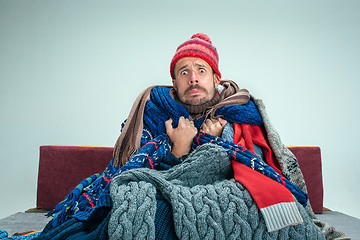 Image showing Bearded Man with Flue Sitting on Sofa at Home. Healthcare Concepts.