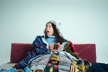 Image showing The young woman with Flue Sitting on Sofa at Home. Healthcare Concepts.