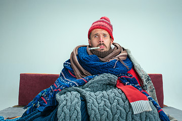 Image showing Bearded Man with Flue Sitting on Sofa at Home. Healthcare Concepts.