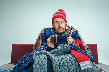 Image showing Bearded Man with Flue Sitting on Sofa at Home. Healthcare Concepts.