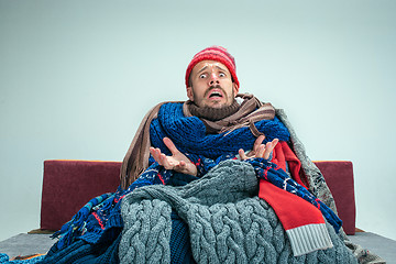 Image showing Bearded Man with Flue Sitting on Sofa at Home. Healthcare Concepts.