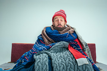 Image showing Bearded Man with Flue Sitting on Sofa at Home. Healthcare Concepts.