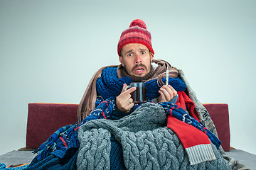 Image showing Bearded Man with Flue Sitting on Sofa at Home. Healthcare Concepts.