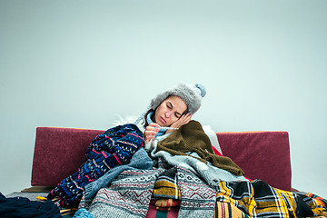 Image showing The young woman with Flue Sitting on Sofa at Home. Healthcare Concepts.