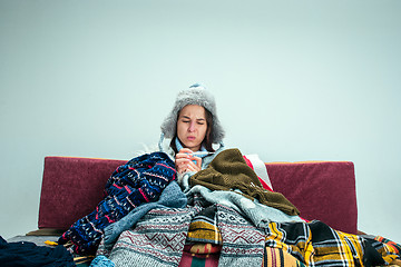 Image showing The young woman with Flue Sitting on Sofa at Home. Healthcare Concepts.