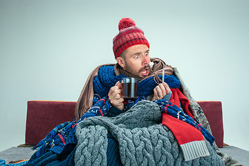 Image showing Bearded Man with Flue Sitting on Sofa at Home. Healthcare Concepts.