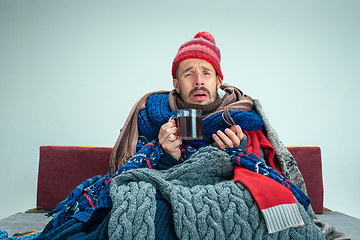 Image showing Bearded Man with Flue Sitting on Sofa at Home. Healthcare Concepts.