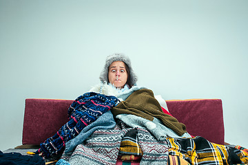 Image showing The young woman with Flue Sitting on Sofa at Home. Healthcare Concepts.