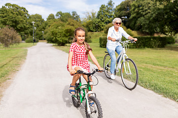 Image showing grandmother and granddaughter cycling at park