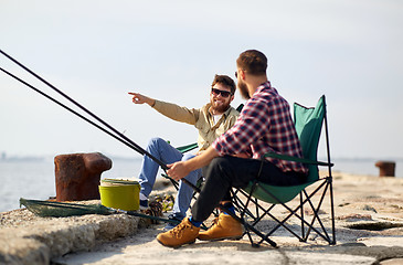 Image showing happy friends with fishing rods on pier