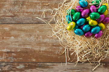 Image showing chocolate eggs in foil wrappers in straw nest