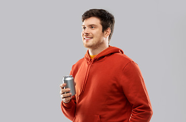 Image showing happy young man drinking soda from tin can