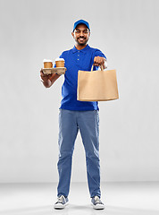 Image showing happy indian delivery man with food and drinks
