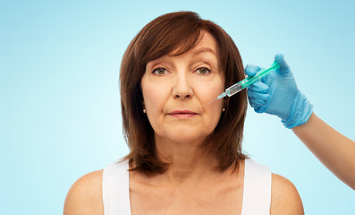 Image showing senior woman and surgeon hand with syringe