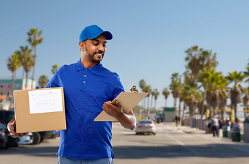 Image showing indian delivery man with parcel box and clipboard