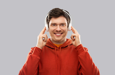 Image showing happy young man in headphones and red hoodie