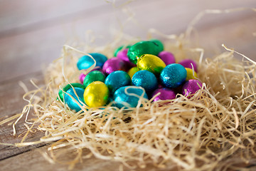 Image showing chocolate eggs in foil wrappers in straw nest