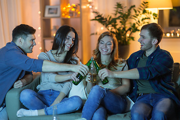 Image showing friends clinking drinks at home in evening